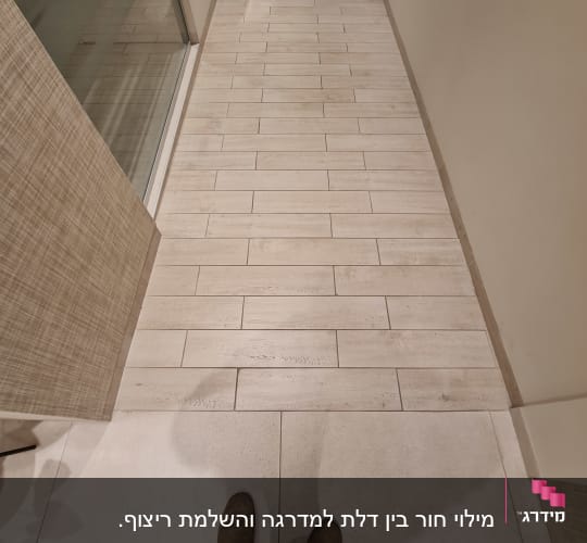 מילוי חור בין דלת למדרגה והשלמת ריצוף. 
